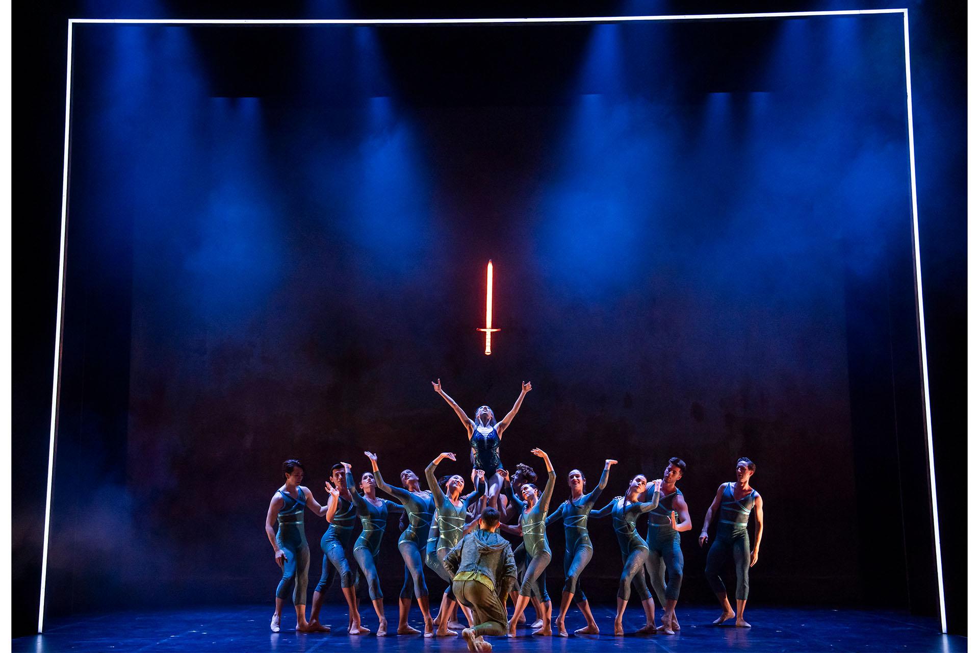 The Ladt of the Lake held aloft by dancers representing the waters raises her arms to the glowing sword just above her head